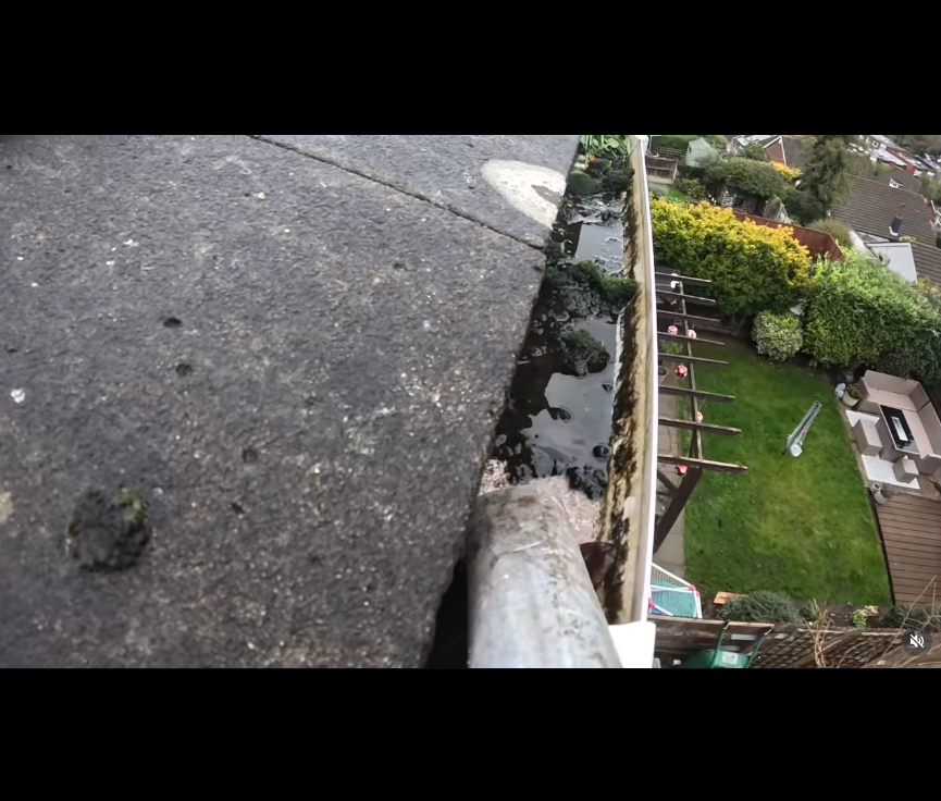 Aerial view of clogged gutter with water and debris