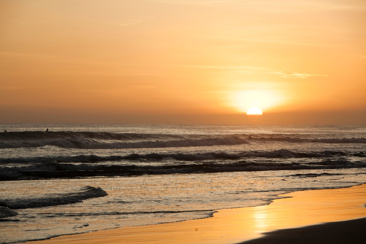 Playa Colorado sunset with golden sky reflecting on ocean waves and sandy beach along Nicaragua's Pacific Coast