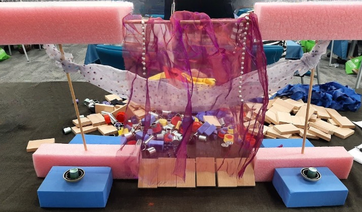 A dramatic loose parts creation using fabric, foam, wood blocks, and beads
