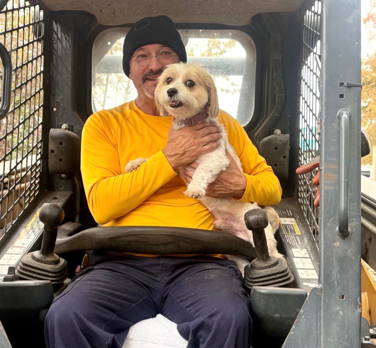 Owner with dog in skid steer