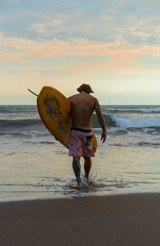 Surfer walking into the waves at Playa Frijolar, Marbella Costa Rica