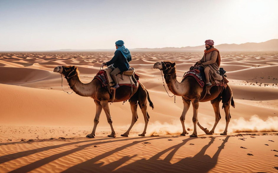 Two people riding camels in Morocco desert
