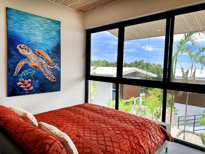 Horizon Suite — king bedroom with sea turtle art and tropical view