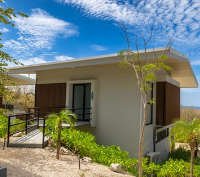 Ocean View Casita — front entrance with blue sky and tropical landscaping