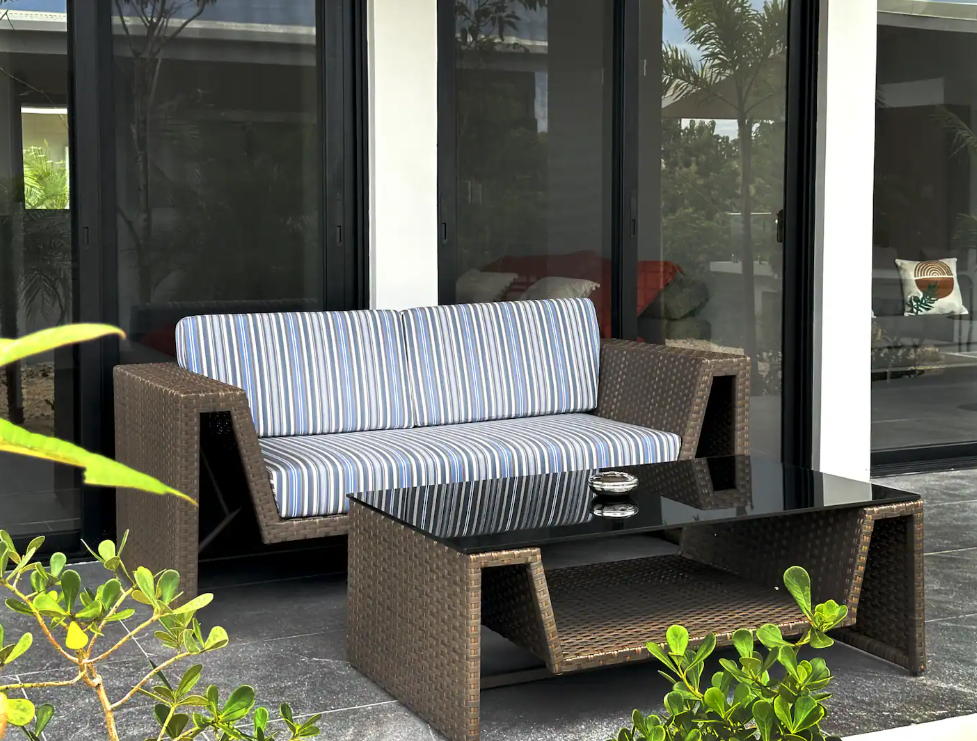 Garden Suite — private terrace lounge with rattan sofa set and garden views