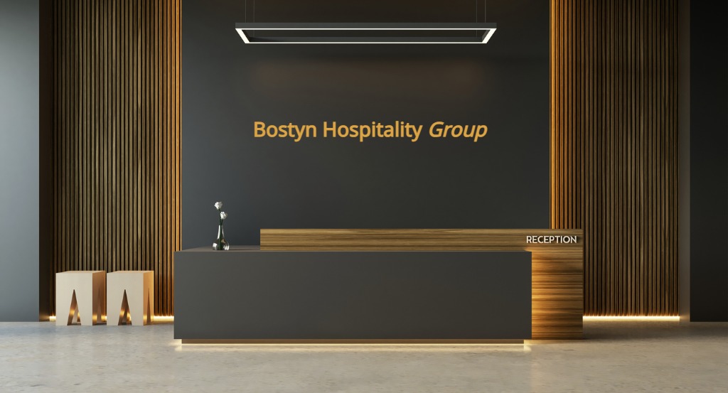 Professional hotel lobby interior - Bostyn Hospitality Group managed property Select-service hotel lobby interior with modern business travel design, professional reception desk and seating area