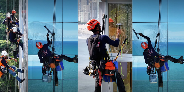 Alpinista industrial em rapel limpando fachada de vidro de prédio alto no Rio de Janeiro