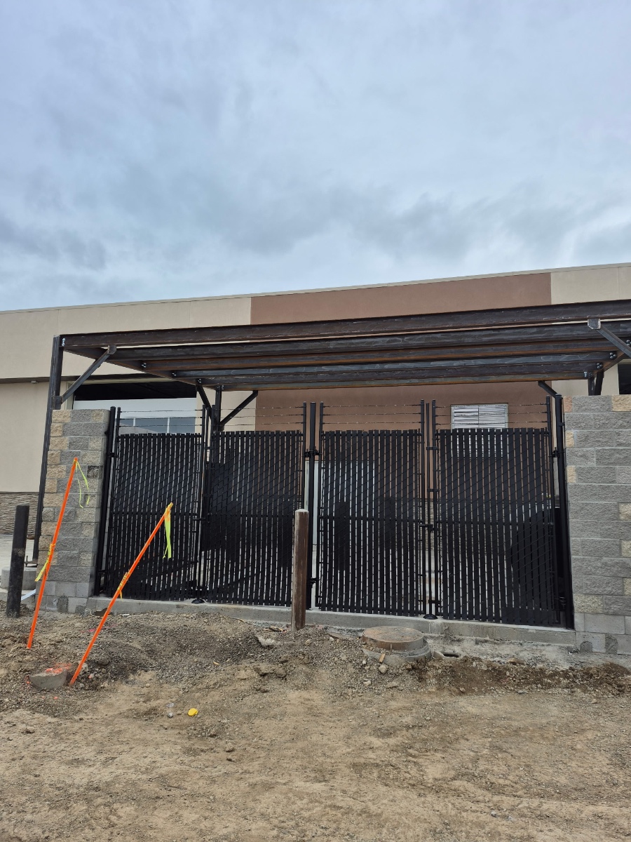 Steel Gate & Canopy Fabrication Custom steel gate and canopy fabrication with privacy slat fencing for commercial property