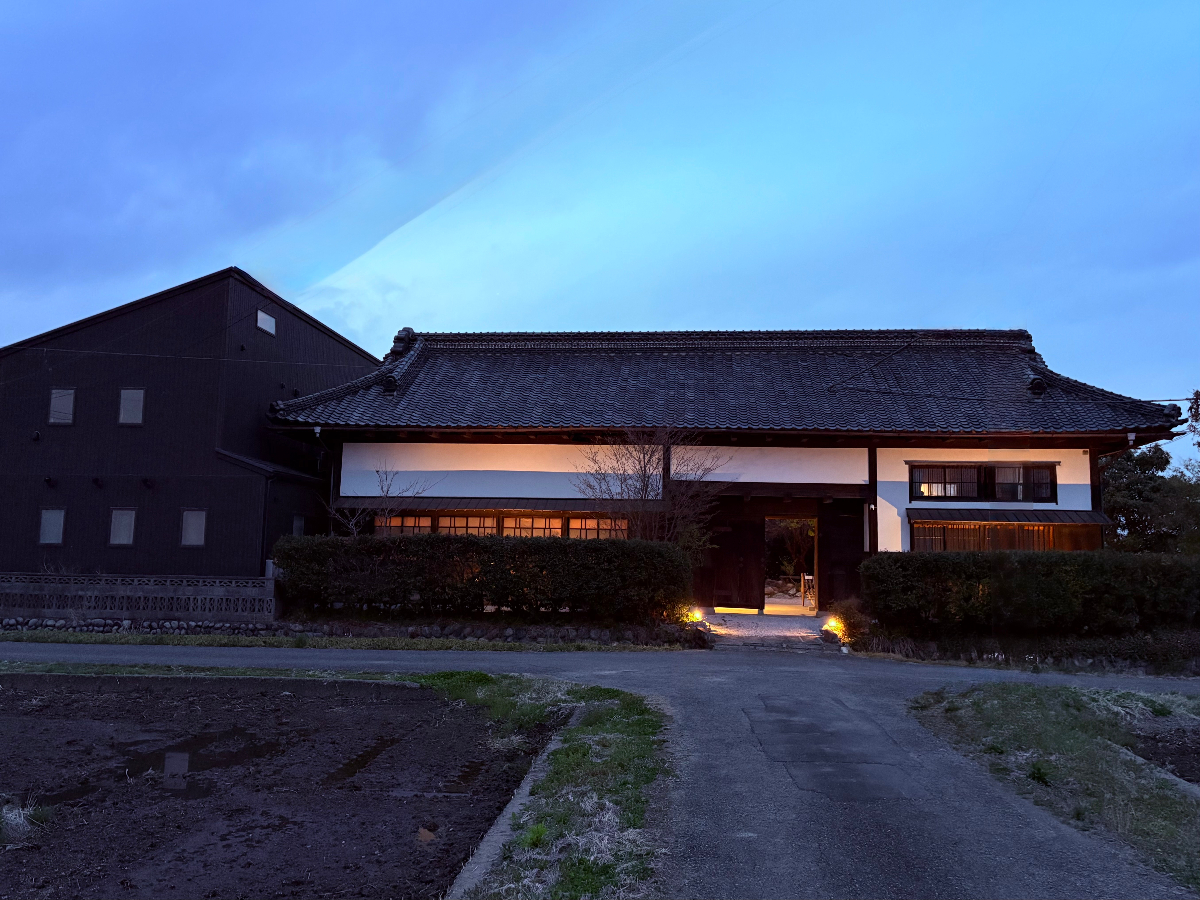 伝統的な日本旅館の外観、美しい日本庭園と瓦屋根が夕暮れに照らされている風景