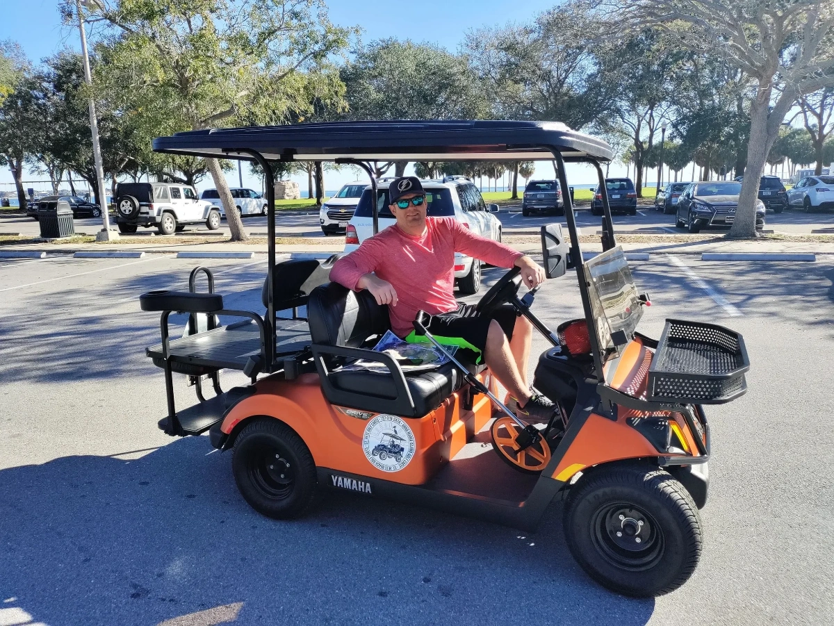 Customer on orange Yamaha golf cart in St. Pete