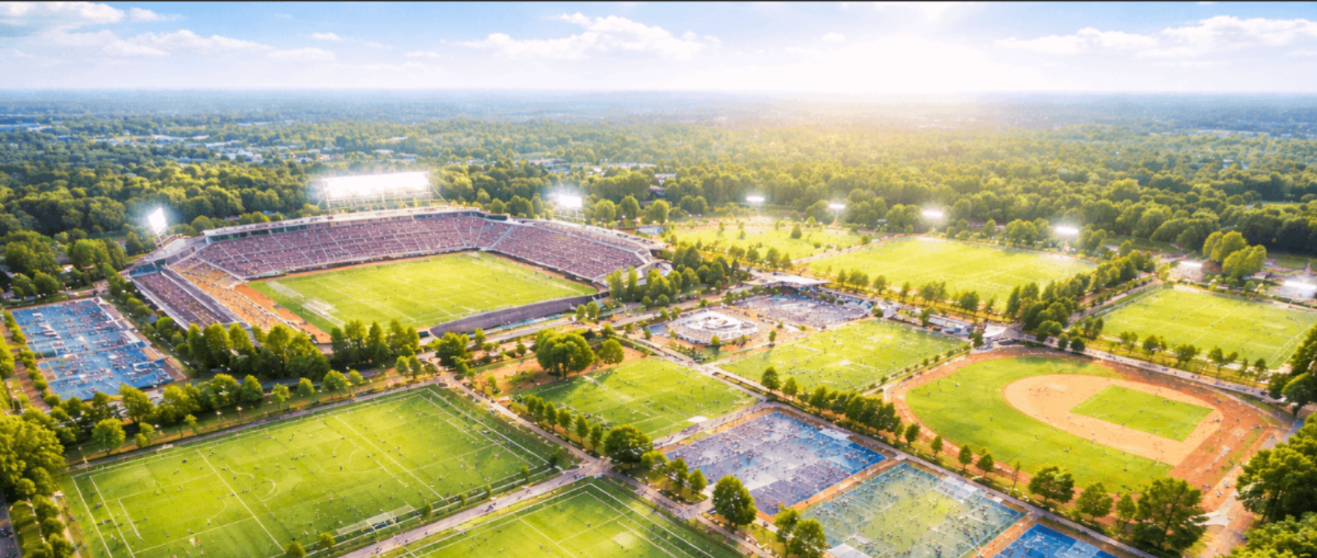 Aerial view of sports complex with multiple fields and stadium