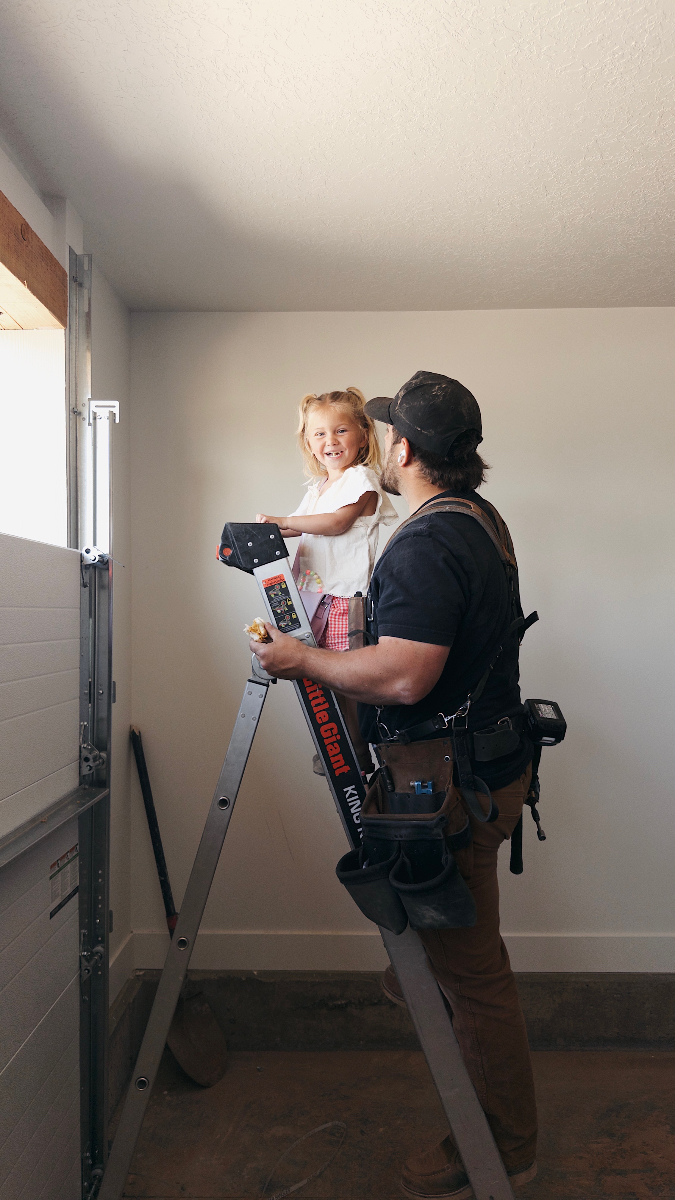 Mike Sorensen working on a garage door with his daughter