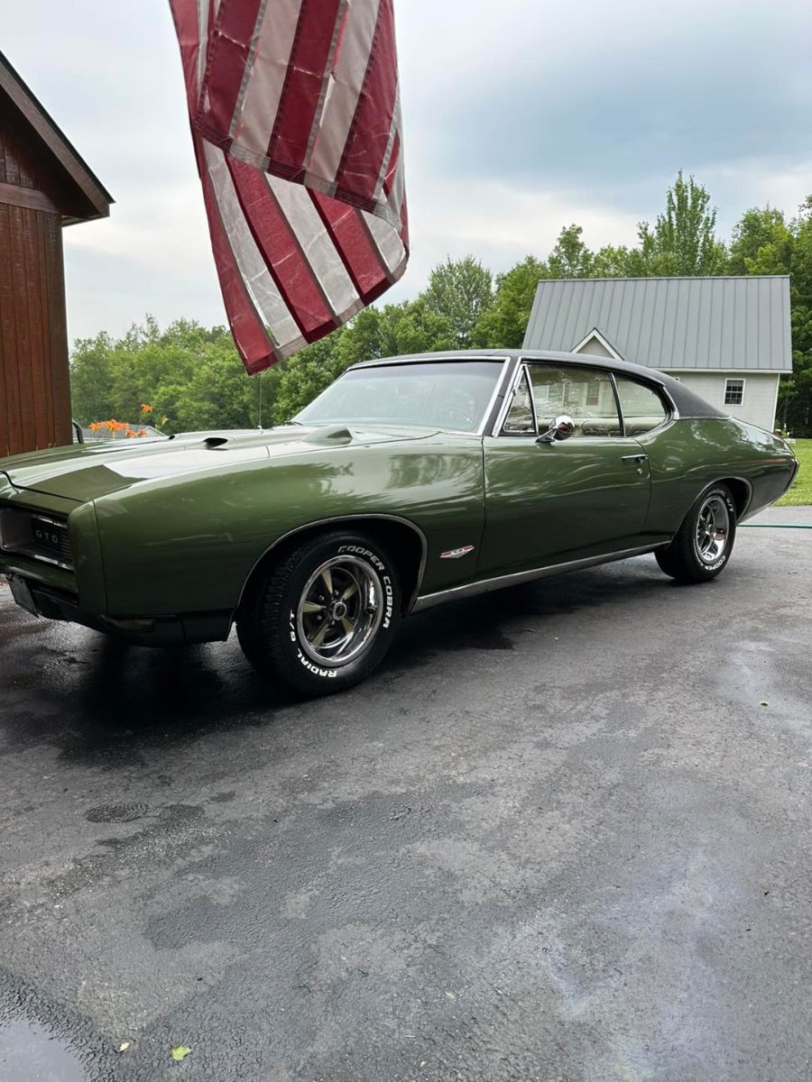 Classic green Pontiac GTO with professional exterior detailing showing mirror-like paint finish