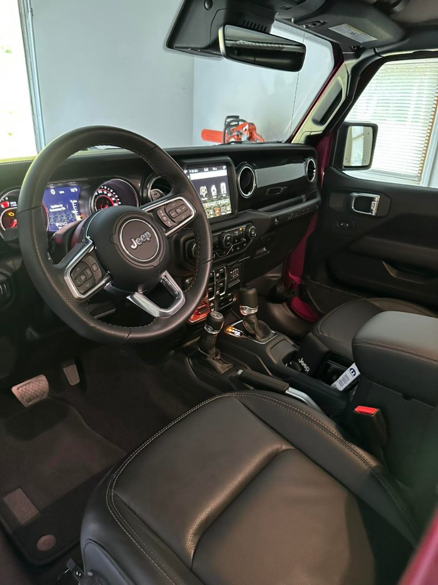 Jeep Wrangler interior detailing with pristine black leather seats and clean dashboard