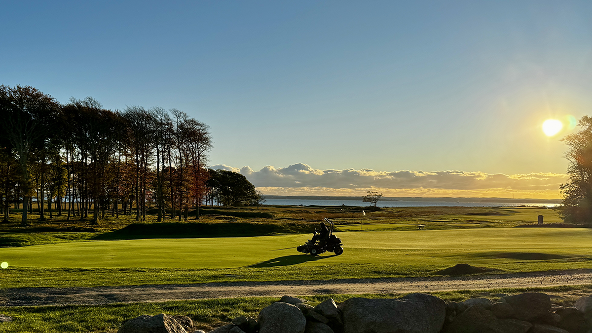 Aerial view of a links-style coastal golf course at golden hour — Bucket List Golf