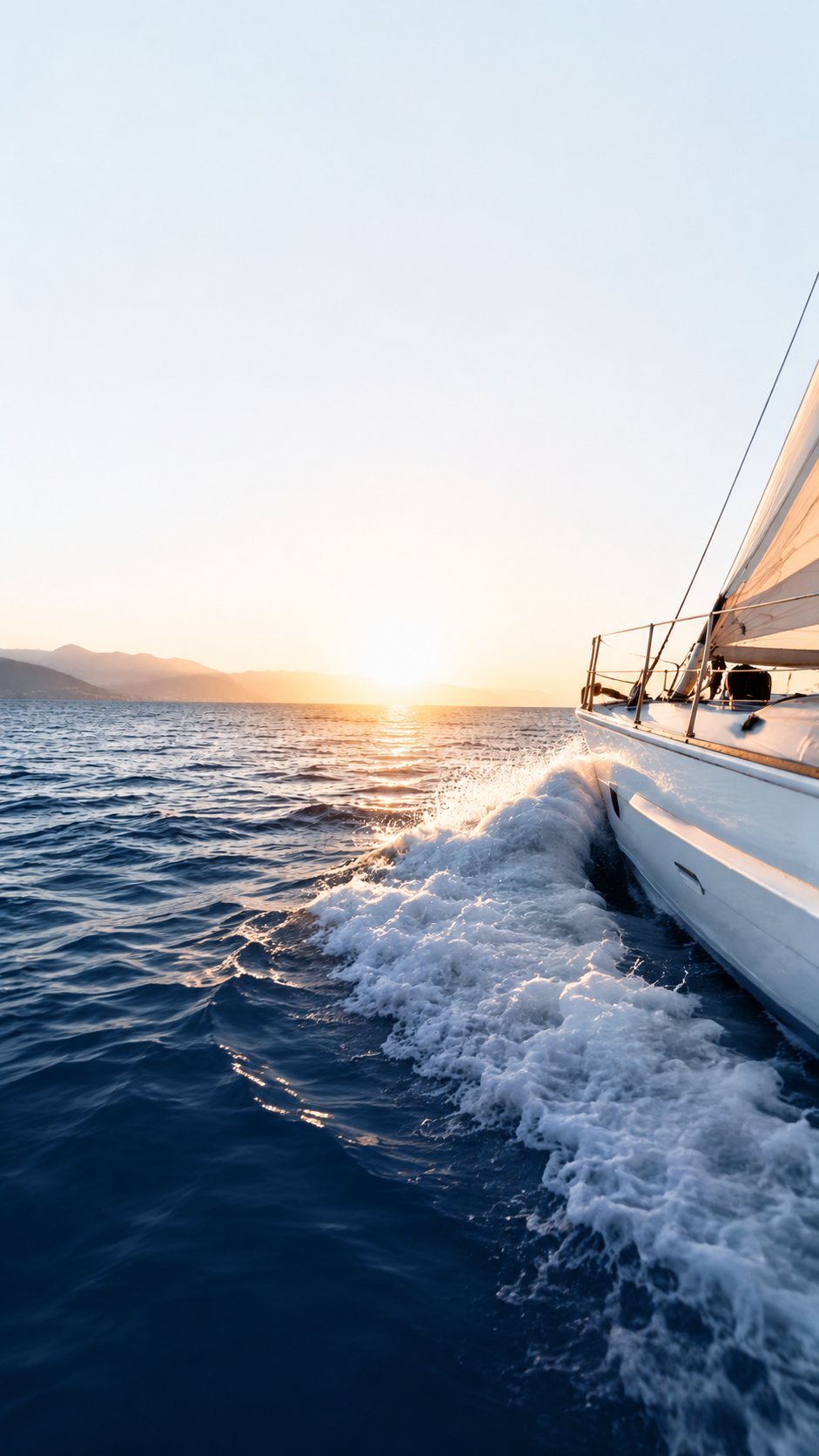 Yacht sailing at sunset with bright sky
