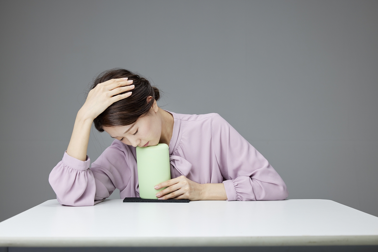 ストレッチルーネ 側屈エクササイズ - 首の側面(胸鎖乳突筋・斜角筋)をストレッチ、頭を横に傾けこめかみ付近にルーネを当てている様子