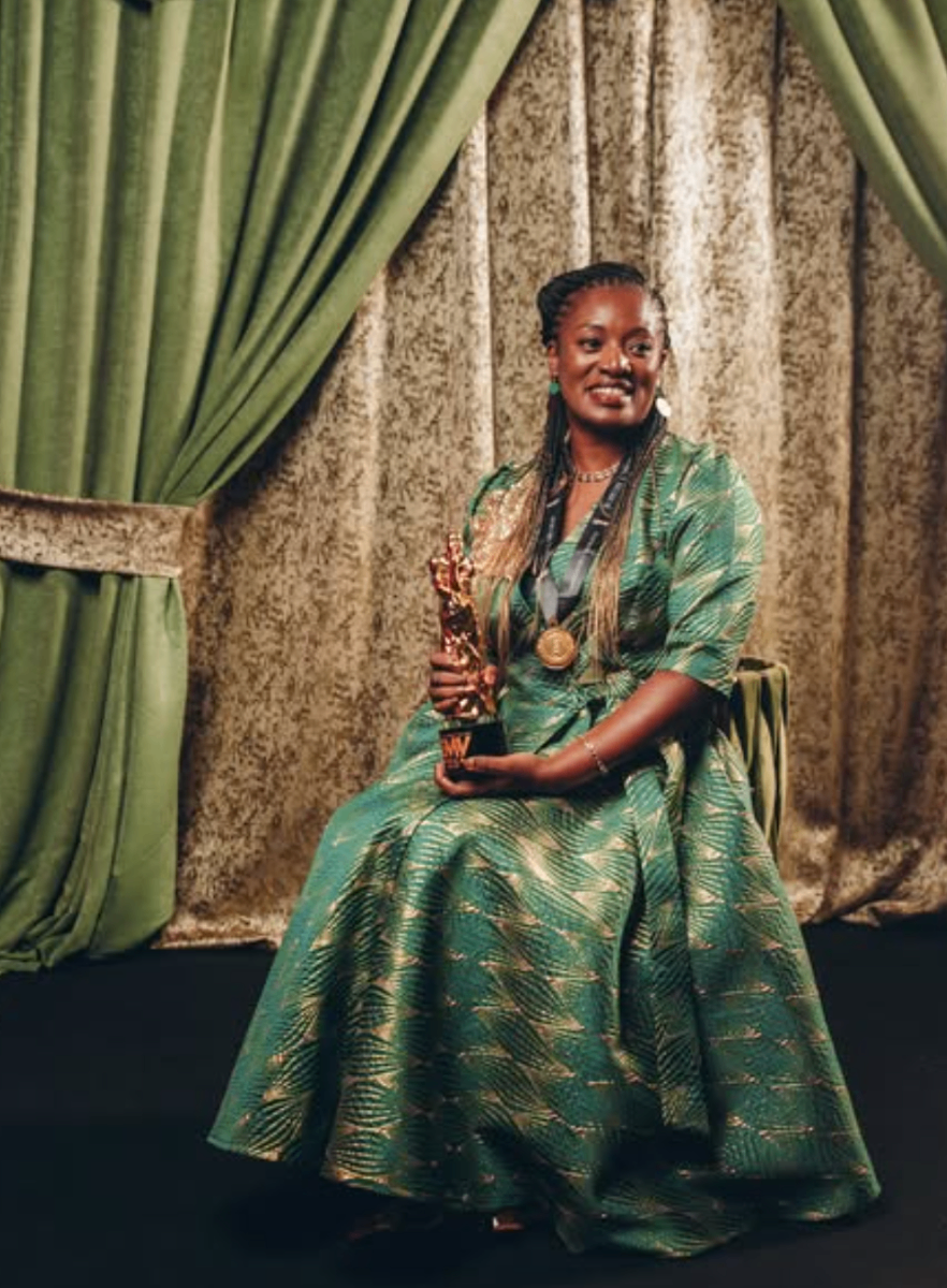 Valerie Labi receiving award in green dress