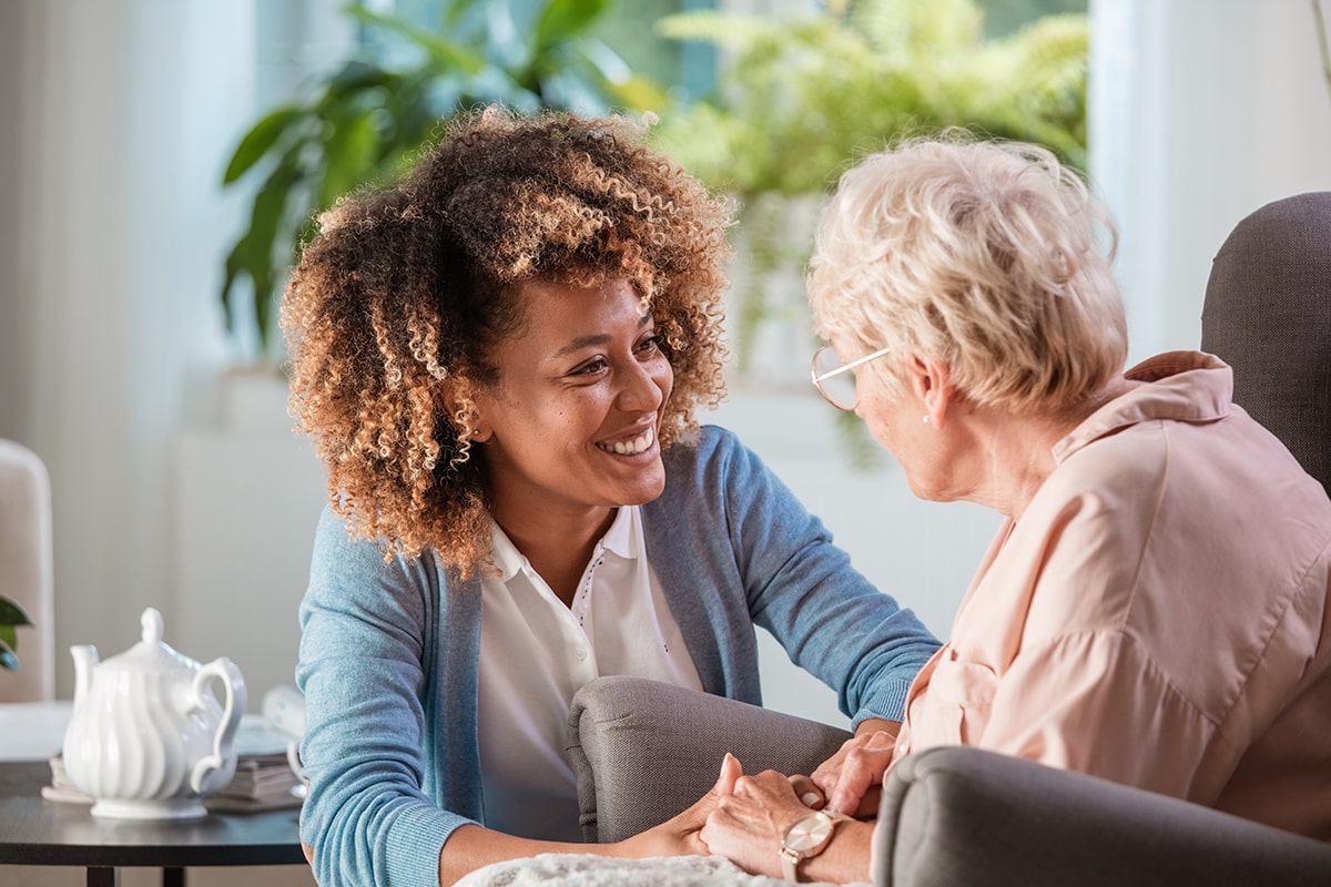 Caregiver and senior smiling together