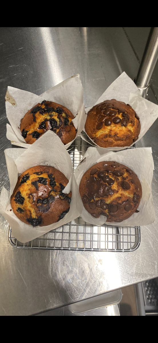 Freshly baked blueberry and chocolate chip muffins cooling on a rack