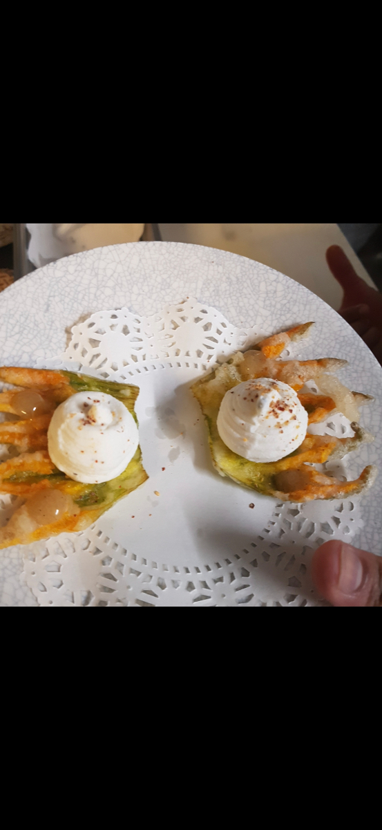 Elegant appetisers with whipped cream on crispy pastry shells on a white plate