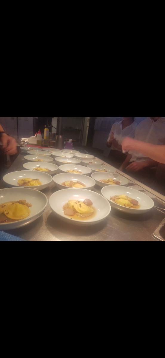 Chefs plating ravioli dishes in a professional kitchen
