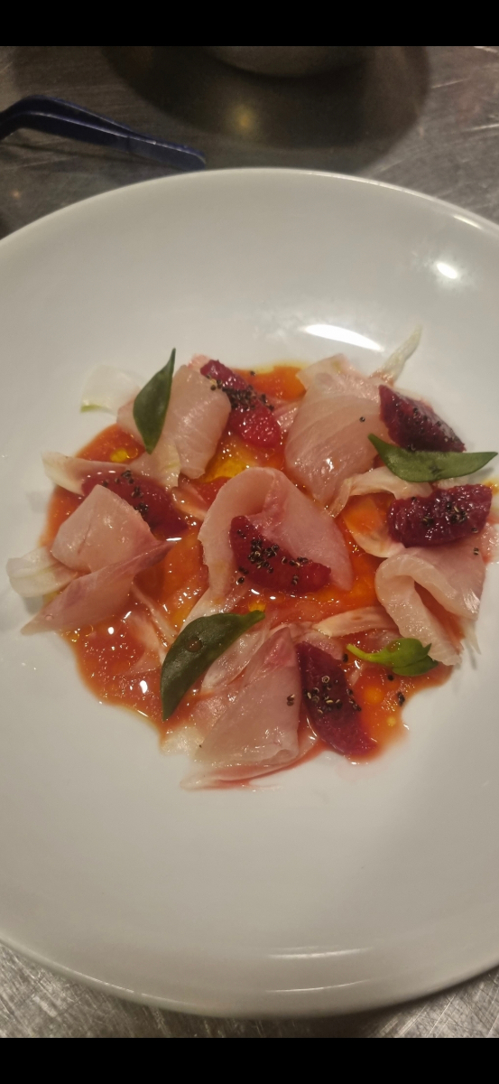 Delicate fish carpaccio with blood orange, fresh herbs and tomato sauce