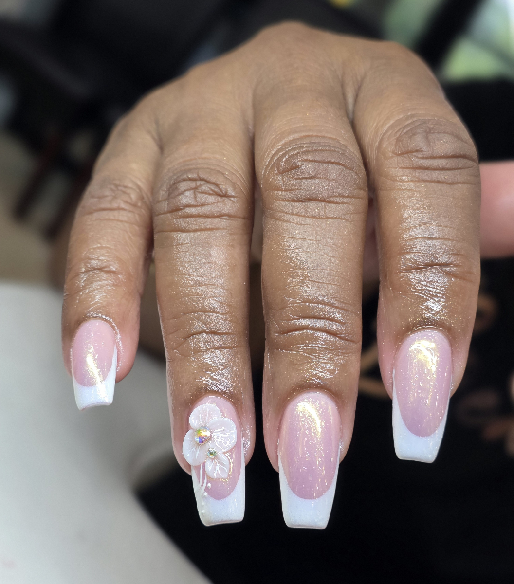 Exquisite French manicure adorned with delicate floral details and professional high-gloss finish