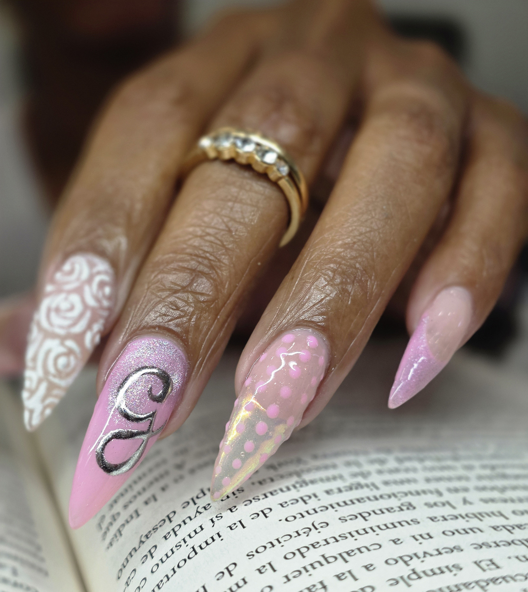 Elegant nail art in coral and pink tones featuring golden floral details, delicate decorative elements and sophisticated professional finish