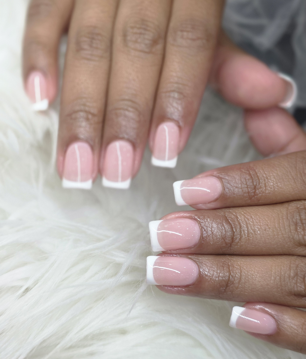 Flawless classic French manicure with pristine white tips and natural pink base showcasing timeless elegance