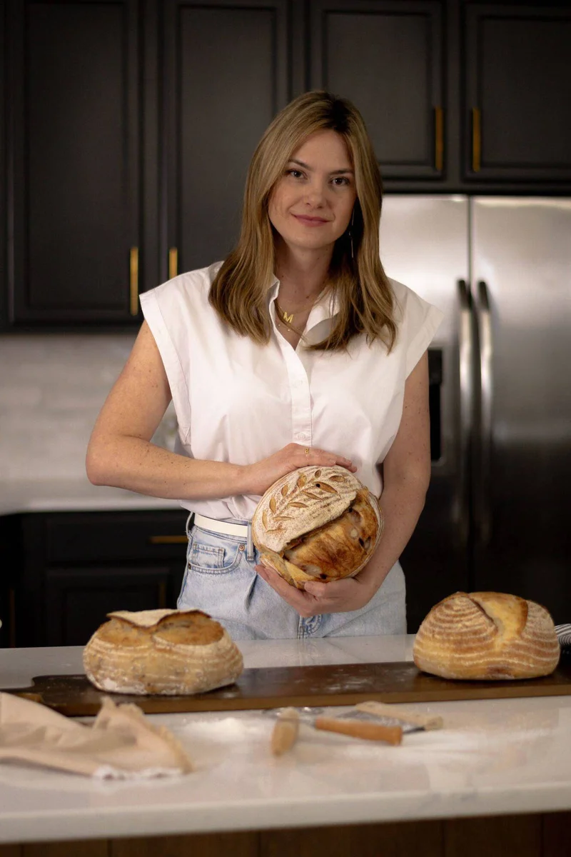 Maira Gimenes, founder of Luv Bakery in Fishers Indiana, holding freshly baked sourdough bread