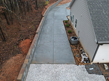 Concrete driveway and retaining wall installation in Braselton GA by Greenstone Landscaping