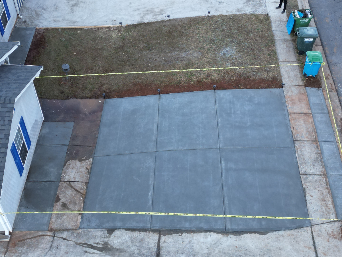 Freshly poured concrete driveway still curing in Buford GA by Greenstone Landscaping — aerial view