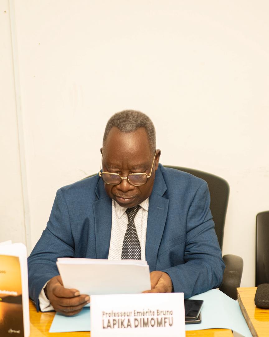 Prof. Émérite Bruno Lapika Dimomfu consultant les documents de travail