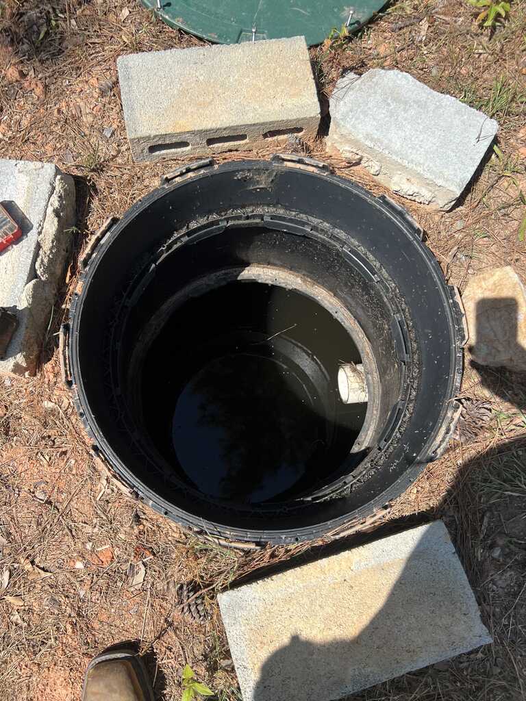 Top-down view inside a septic riser showing the access opening and internal components in Rock Hill SC