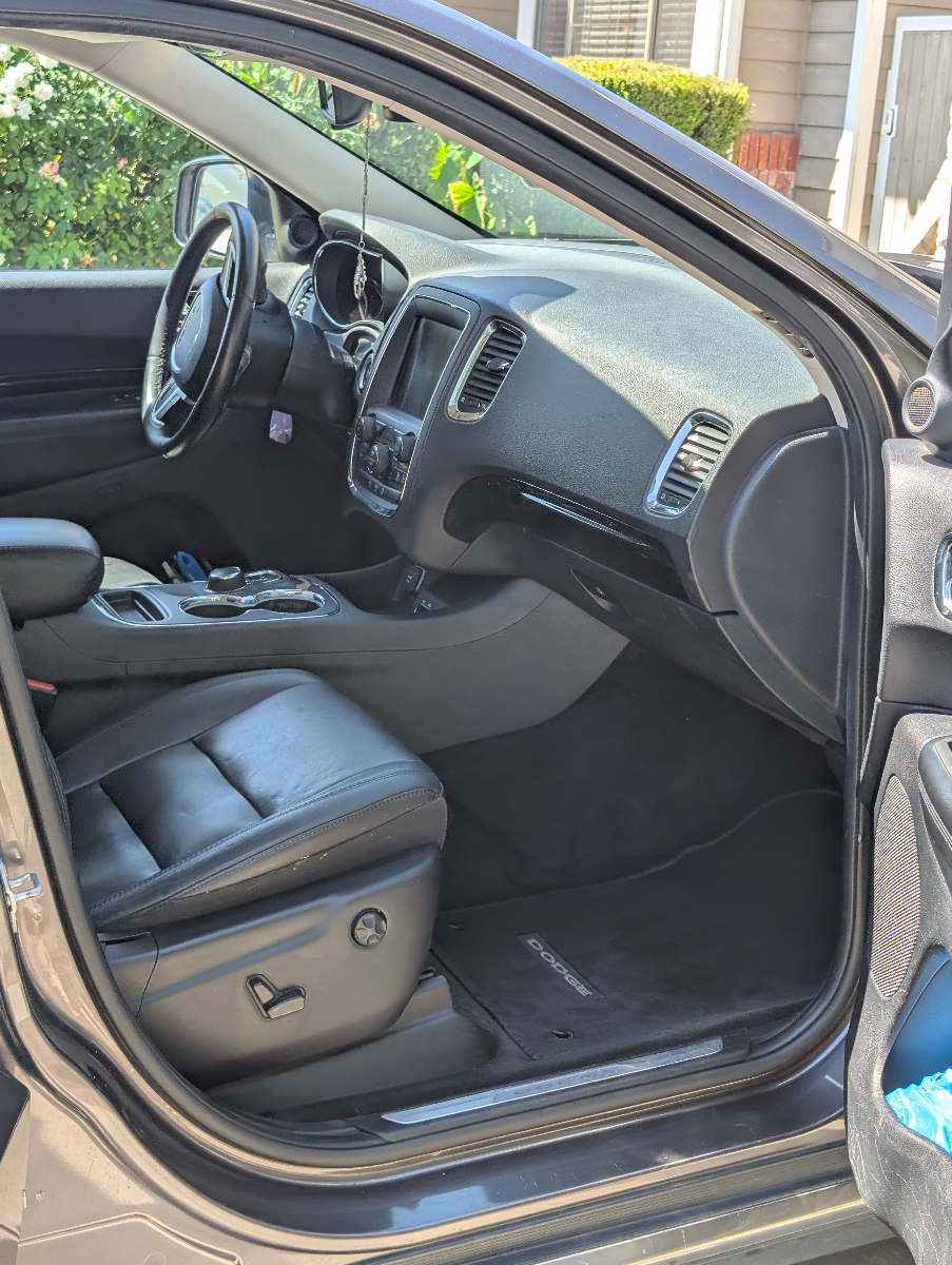 Professional interior detailing of Dodge vehicle showing pristine dashboard, premium leather seats, center console cleaning, and complete cabin restoration with meticulous attention to detail