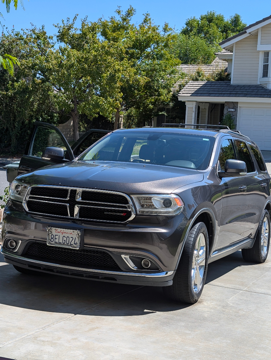Professional exterior detailing of gray Dodge Durango SUV showcasing pristine paint finish, clean chrome details, and meticulous attention to large vehicle detailing
