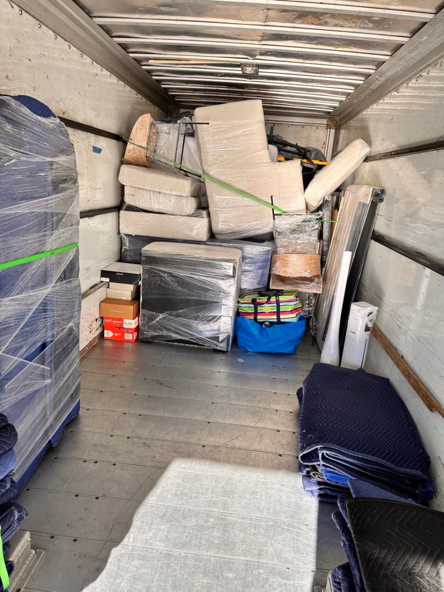 Inside Precision Moving truck showing carefully organized furniture with protective blankets and secure strapping for safe transport
