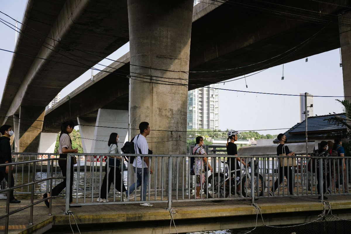Urban Thailand scene with cyclists under bridge