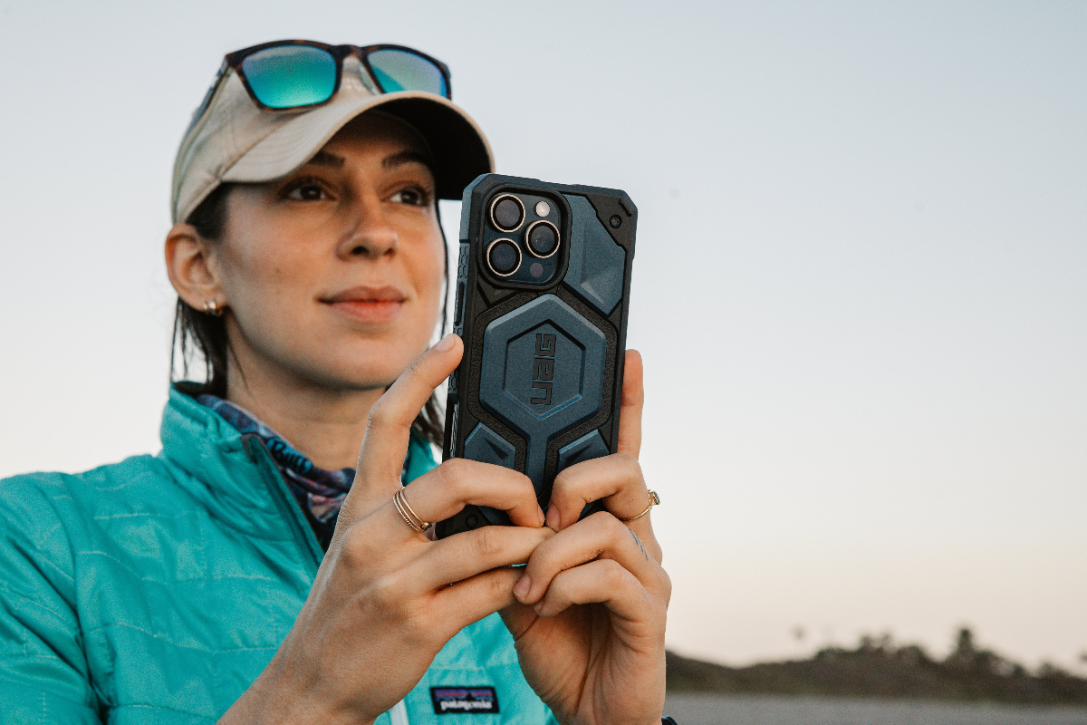 Allie using phone with UAG case outdoors