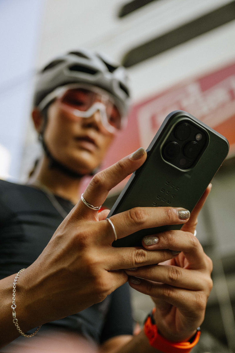 Gift Muzcali using phone with UAG case while wearing cycling gear