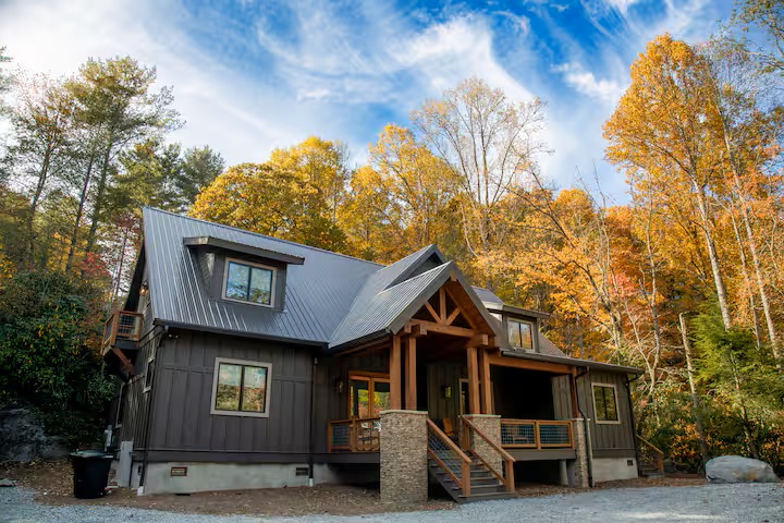 Glen Falls Luxury Cabin exterior in fall with colorful autumn trees in Highlands NC
