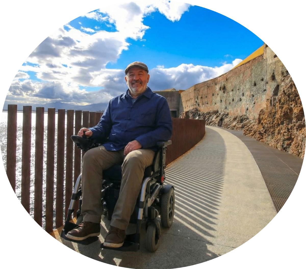 Homme souriant en fauteuil roulant électrique