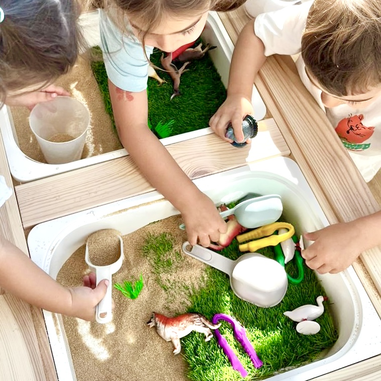 Niños jugando y explorando en La Aldea con materiales sensoriales y juegos educativos