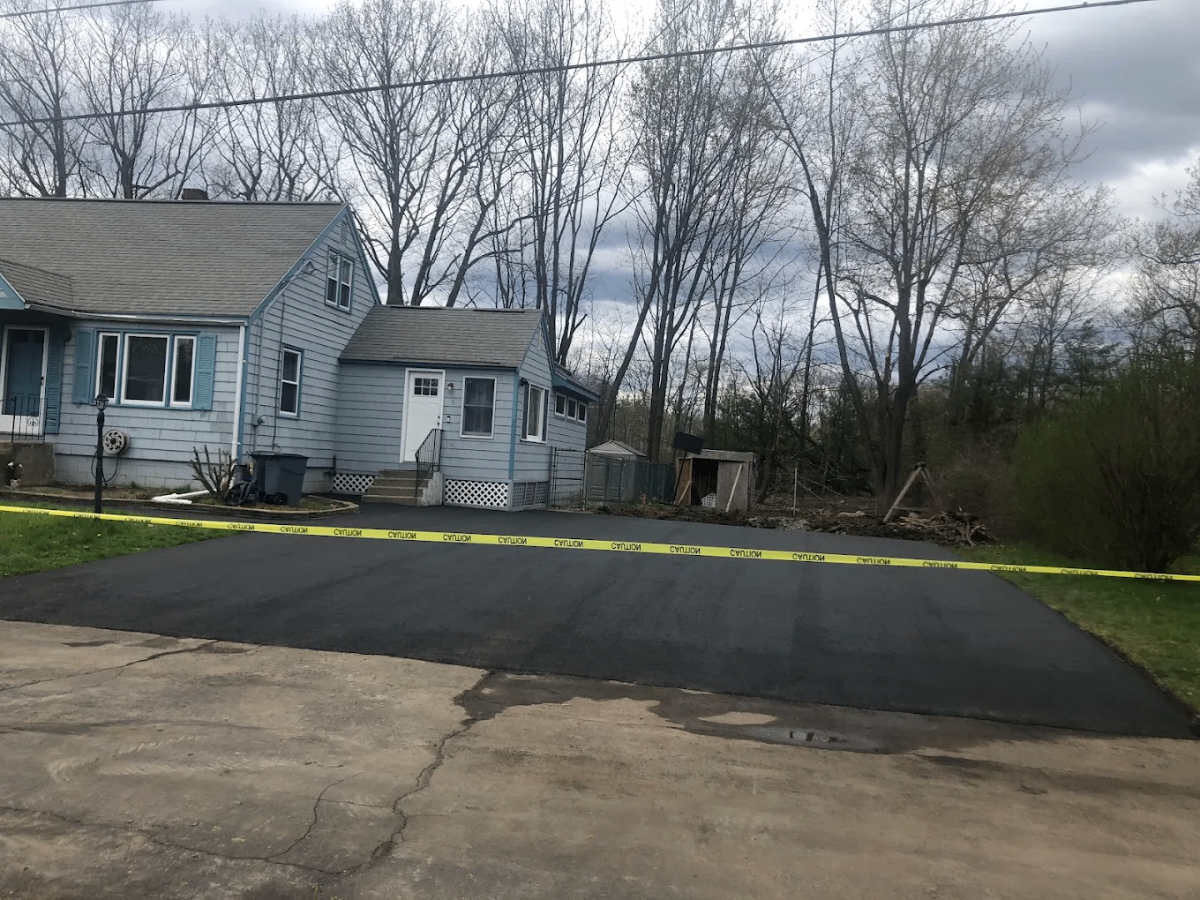 After: Fresh jet-black asphalt driveway — completed by Unique Asphalt Paving