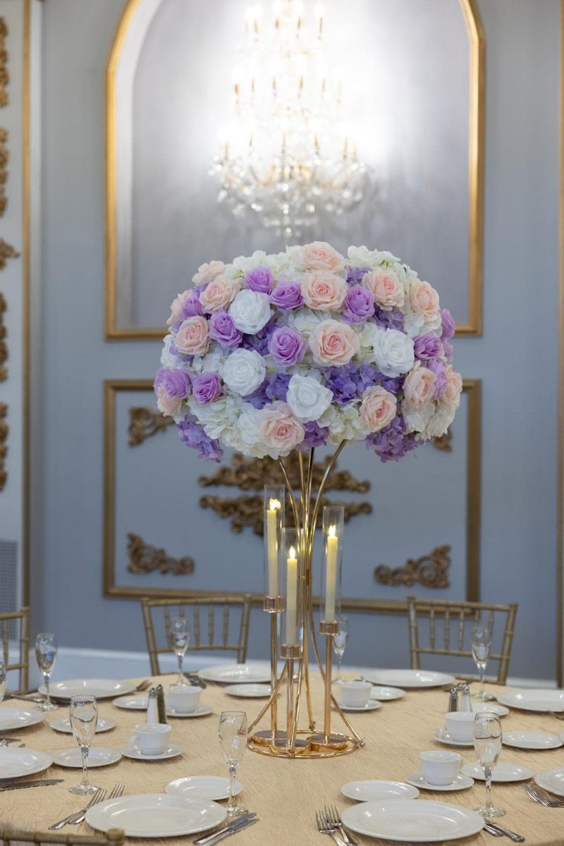 White Hydrangea with white, pink and lavender roses on gold hourglass stand with taper candle holders