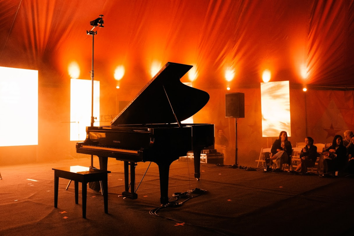 Piano de cola en espacio inmersivo CNC — carpa roja con iluminación escénica