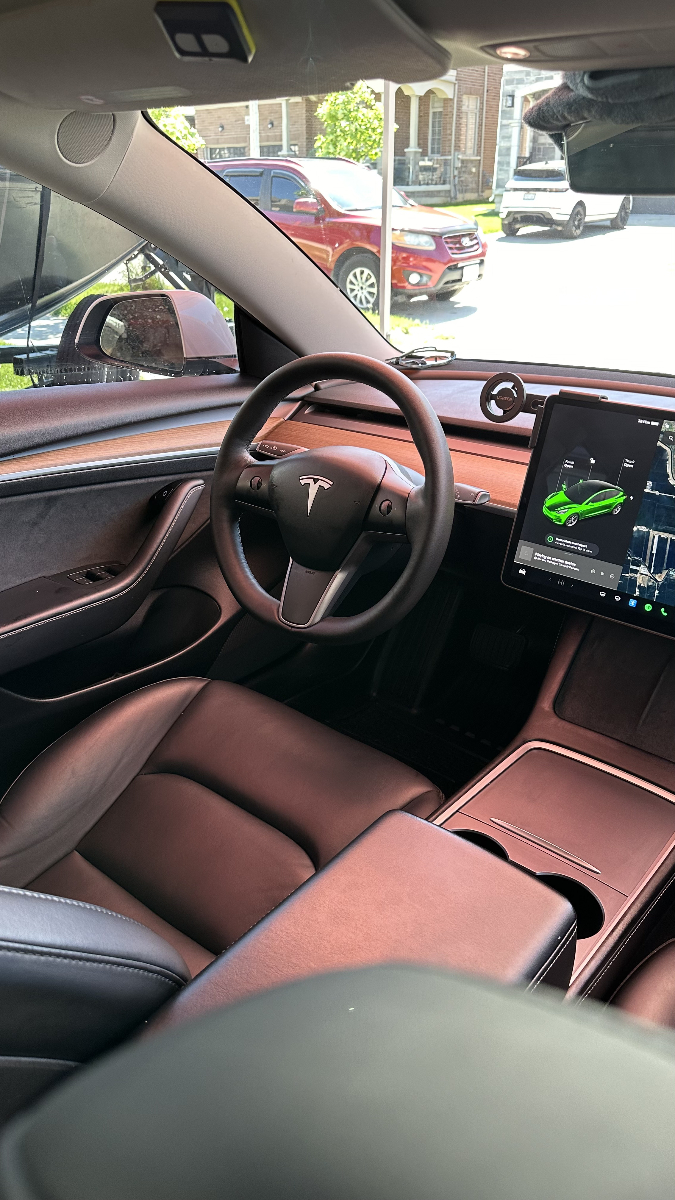 Professional auto detailing service showing skilled technician carefully cleaning luxury vehicle exterior with premium foam and microfiber cloths in bright clean environment with modern equipment and tools