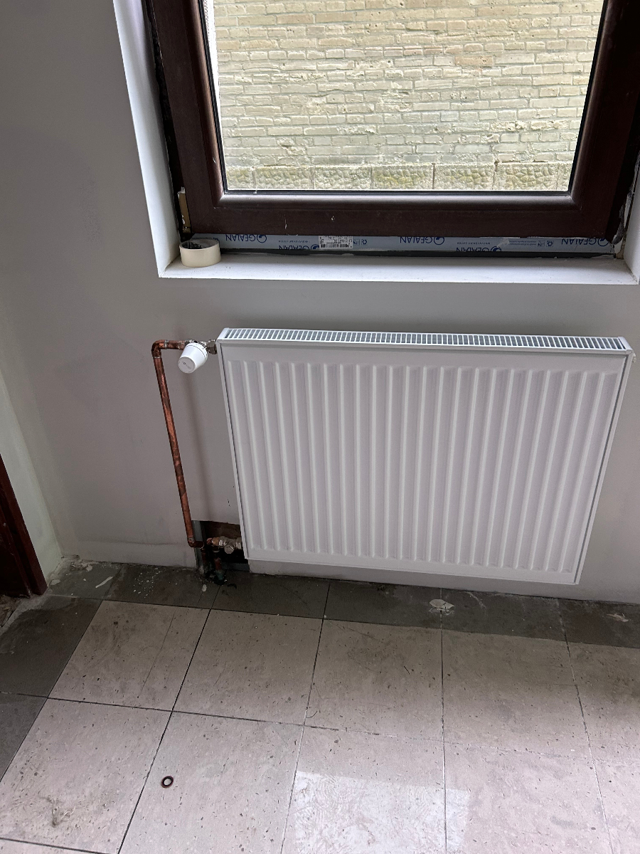 Instalace radiátoru pod střešním oknem v podkrovní místnosti