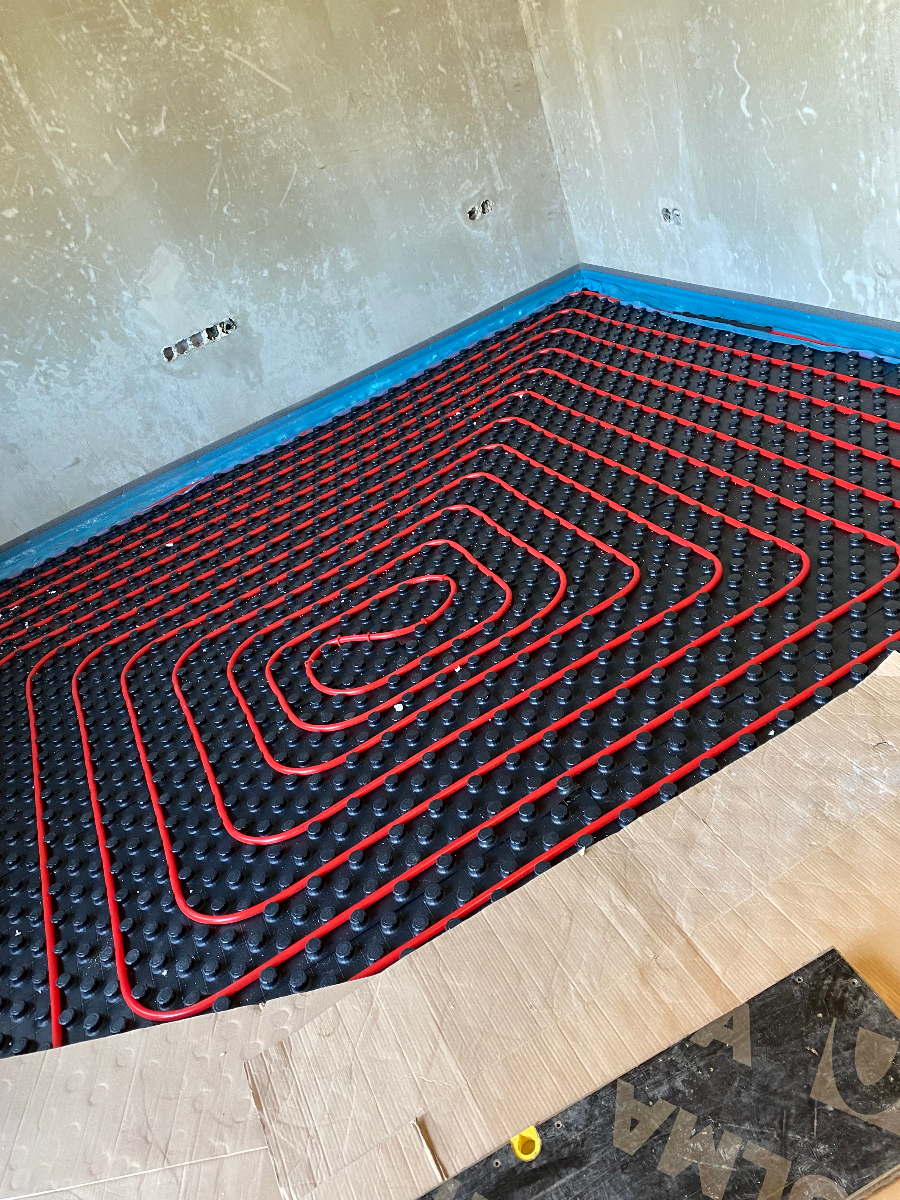 Instalace podlahového vytápění s detailním rozložením topných trubek na izolační podložce